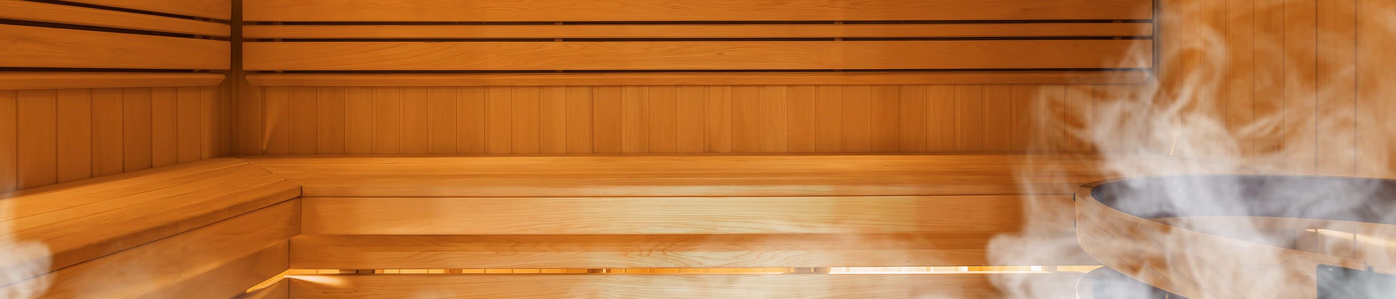 Saunakabine aus Holz mit Bänken und Ofen mit Dampf
