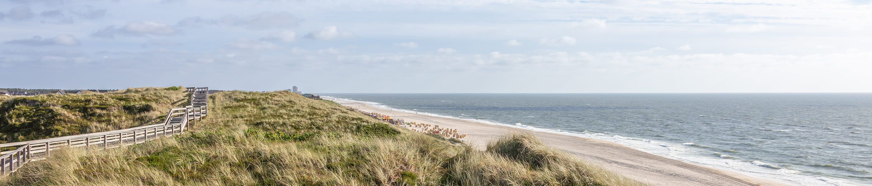 Dünenlandschaft mit Holzsteg und Blick auf Strand und Nordsee