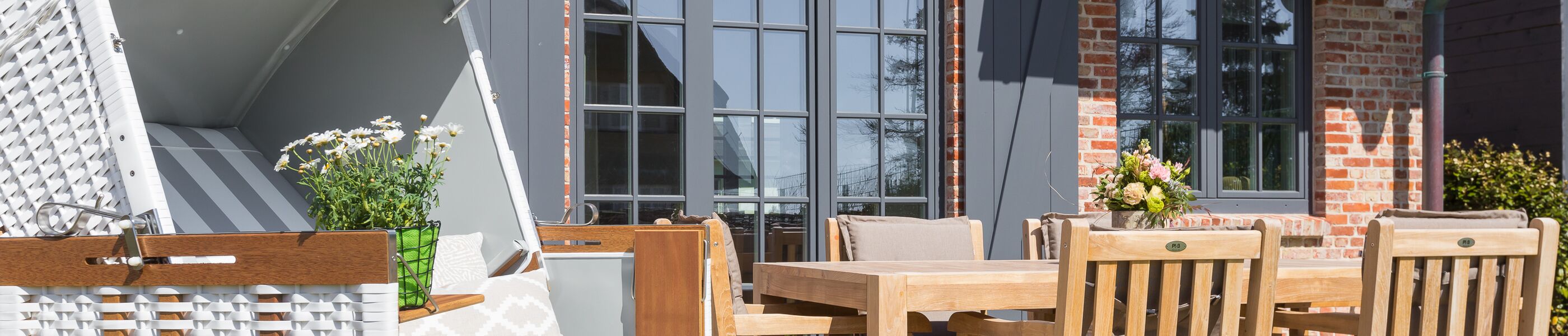 Terrasse mit Holzmöbeln und Strandkorb